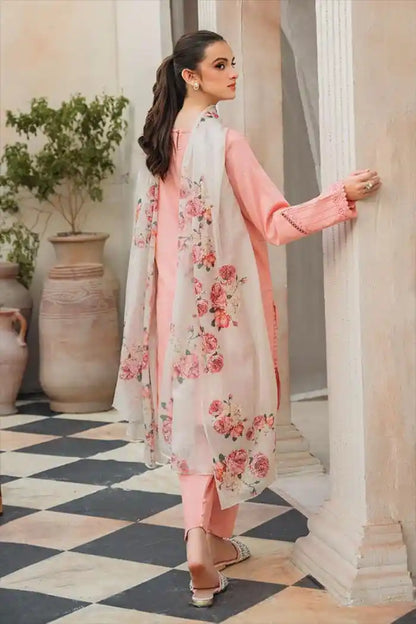 Woman in a floral and pink traditional outfit standing in an elegant interior setting.